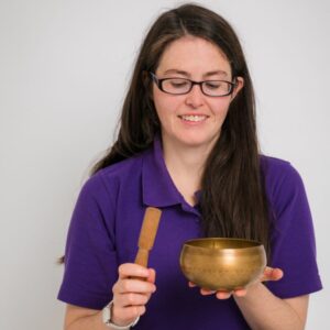 Katie McGreal Solas Relaxation holding a singing bowl for Meditation Class