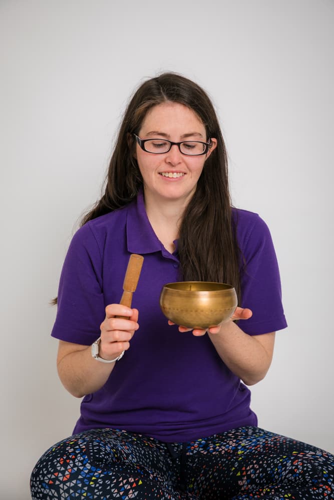 Katie McGreal Founder | Solas Relaxation holding a singing bowl